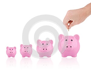 Saving money concept - Putting coin into piggy bank