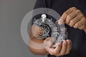Saving money for education concept. the idea of saving or investing. A student holding a glass jar piggy bank with an icon