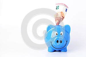 Saving money with Euro banknote into blue piggy bank Horizontal views