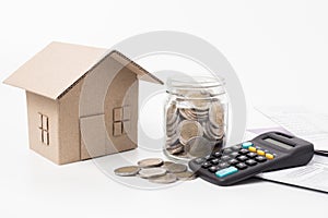 Saving money and finances concept ,home model and coin money with calculator on awhite background