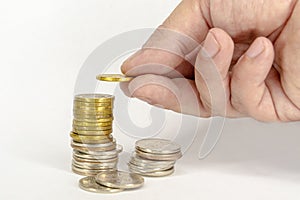 saving money hand puts coins on a stack on a white background. finance and accounting concept. image for project and design,