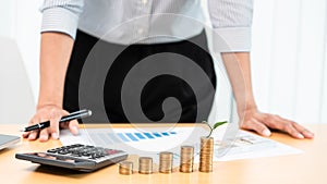 Saving money and investment concept, Business accountant woman stacking coins into increasing columns stack for budget behind desk