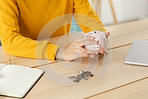 Saving money investment for future. Female woman hands holding pink piggy bank and putting money coin. Saving investment
