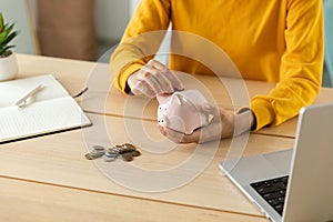 Saving money investment for future. Female woman hands holding pink piggy bank and putting money coin. Saving investment