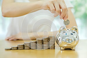 Saving money-young woman putting a coin into a money-box