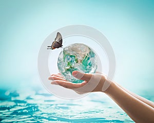 Saving water, world water day, environmental ecology protection, earth day concept with woman`s hand holding green planet