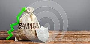 Savings bag, green up arrow and shield. Protection funds and investments, security garnishment and augmentation. Deposit at bank.