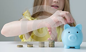 Savings, budget planning. Happy smart small 9s teen kid make donation contribution in piggy bank