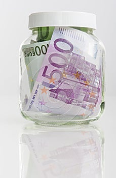 Savings Concept: Bundle of European Currency Banknotes Put in Jar