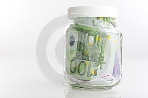 Savings Concept: Bundle of European Currency Banknotes Put in Jar Isolated