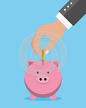 Savings concept. Man hand putting coin into piggy bank.