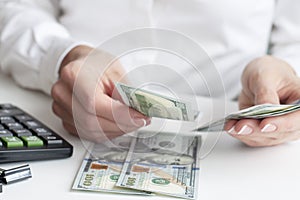 savings, finances, economy concept - close up of woman with calculator counting money and making notes at home.