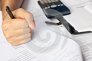 Savings, finances, economy and home concept - close up of man with calculator counting making notes in the crisis at home.
