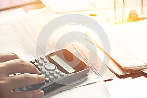 Savings, finances, economy and home concept - close up of man with calculator counting making notes at home