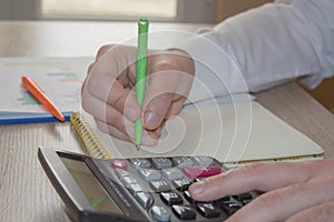 Savings, finances, economy and home concept - close up of man with calculator counting money and making notes