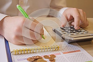 Savings, finances, economy and home concept - close up of man with calculator counting money and making notes