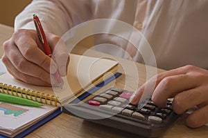 Savings, finances, economy and home concept - close up of man with calculator counting money and making notes