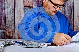 savings, finances, economy and home concept close up of man with calculator counting money and making notes at home