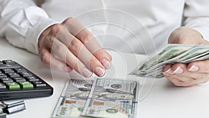 savings, finances, economy and home concept - close up of woman with calculator counting money and making notes at home