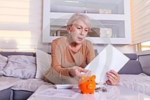 Savings, money, annuity insurance, retirement and people concept - Senior woman hand putting coin into piggy bank. Senior old