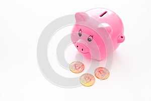 Savings. Moneybox in shape of pig near coins on white background copy space