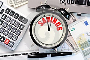 Savings over time concept suggested by a retro alarm clock with the word â€œsavingsâ€ written on its display