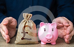 Savings are protected. Protect piggy bank and british pound sterling money bag.