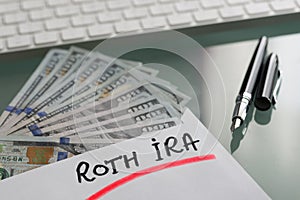 Savings for retirement concept with Roth Ira written on white envelope with cash US dollars