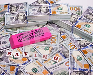 Savings: Scattered and stacked hundred dollar bills with a pink eraser really big mistakes