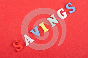 SAVINGS word on red background composed from colorful abc alphabet block wooden letters, copy space for ad text. Learning english