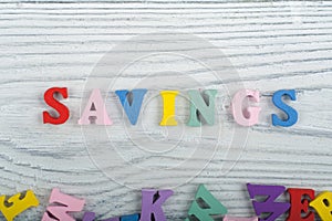SAVINGS word on wooden background composed from colorful abc alphabet block wooden letters, copy space for ad text. Learning