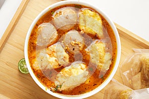 Savor a bowl of Cuankie meatball soup with round meatballs, tofu, fried wontons, and savory spicy broth