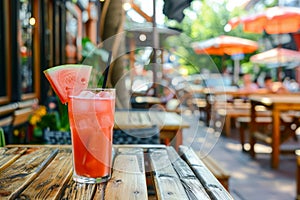 Savor a delightful watermelon cocktail in a glass on a rustic wooden table at a quaint street cafe photo