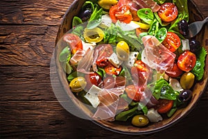 Savor the season Vibrant summer salad featuring olives, tomatoes, and prosciutto