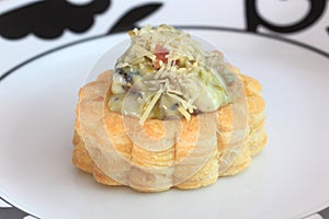 Savory filled pastry case or vol-au-vent on dinner plate