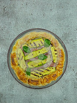 savory pie with courgettes and basil on a round plate, italian plate photo