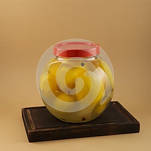 Savory salted lemon fruits in glass jar, close-up