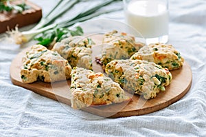 Savory scones with feta mozzarella and green herbs on a wooden b