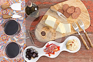 Savory snacks on a rustic table with red wine