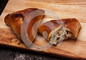 Savory stuffed patties on a Board on black baking tray. Country house style. Authentically