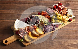 A Savoury Charcuterie Board Covered in Meats Olives Peppers Berries and Cheese photo