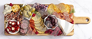 A Savoury Charcuterie Board Covered in Meats Olives Peppers Berries and Cheese photo