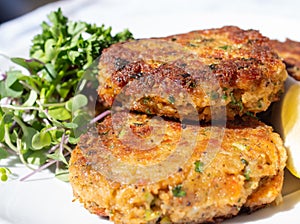 Savoury, crisp and starchy, fishcakes, crab cakes..Fried fish patties served on a plate with salad on the side photo