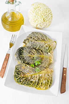 Savoy cabbage rolls on white dish.