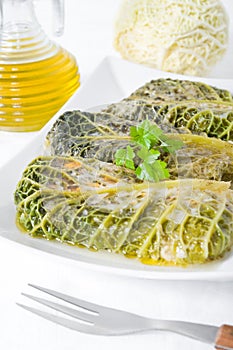 Savoy cabbage rolls on white dish.