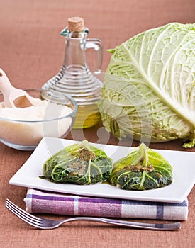 Savoy cabbage rolls on white dish.