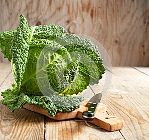 Savoy cabbage on wooden chopping board