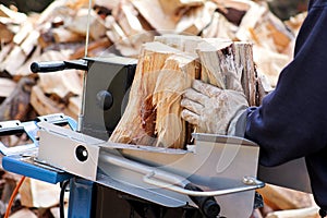 Saw cutting wood for winter. A man cutting firewood for the winter using a modern machine lumber saw.