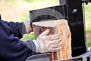 Saw cutting wood for winter. A man cutting firewood for the winter using a modern machine lumber saw.