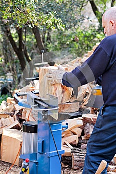 Saw cutting wood for winter. A man cutting firewood for the winter using a modern machine lumber saw.